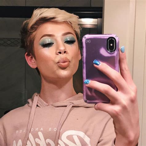 A Woman Taking A Selfie With Her Phone In Front Of Her Face And Wearing Makeup