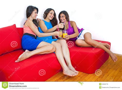 Three Cute Girlfriends Laughing And Having Fun At Home Stock Photo