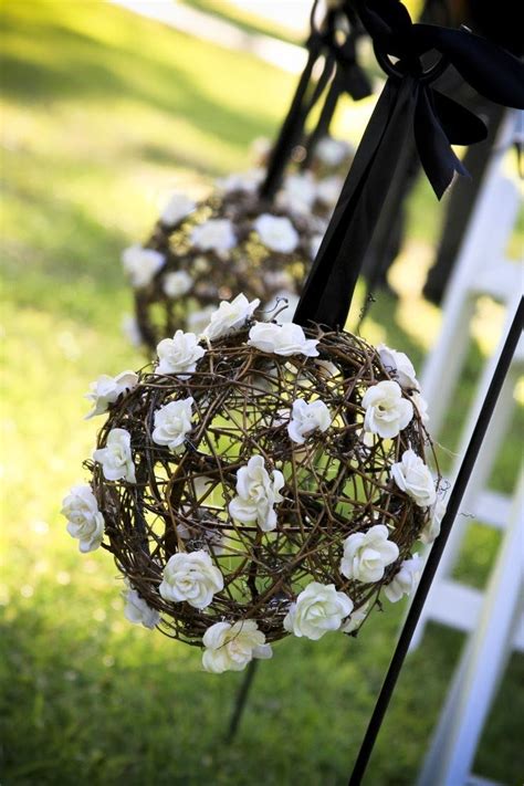 White Flowers Are Hanging From The Back Of An Outdoor Wedding Ceremony