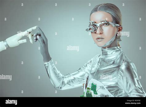 Cyborg Touching Robotic Arm And Looking At Camera Isolated On Grey