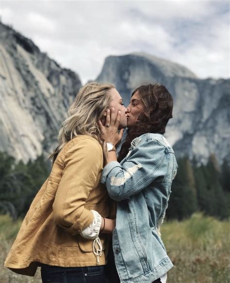 Cute Lesbian Couple Kissing In Front Of A Mountain