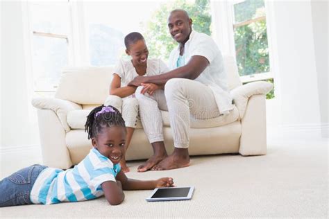 pretty couple sitting on couch and their daughter using digital tablet stock image image of