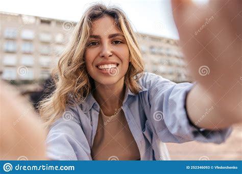 Pretty Young Caucasian Woman With Piercing Smiles Broadly Relaxing