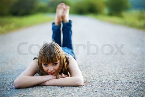 Ung Kvinde Liggende På Vejen Og Se På Kamera Stock Foto Colourbox