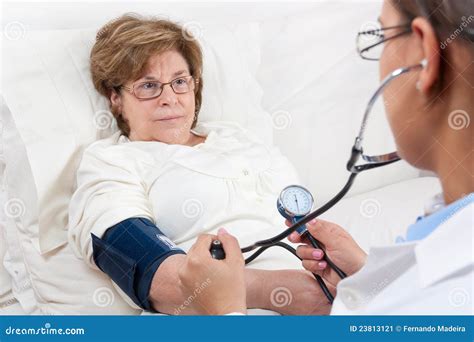 Doctor Measuring Blood Pressure On Senior Patient Stock Image Image