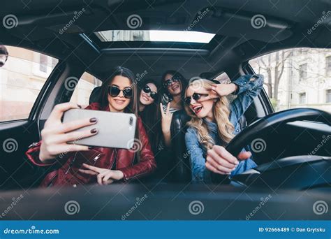Group Of Girls Having Fun In The Car And Taking Selfies With Camera On Road Trip Stock Image
