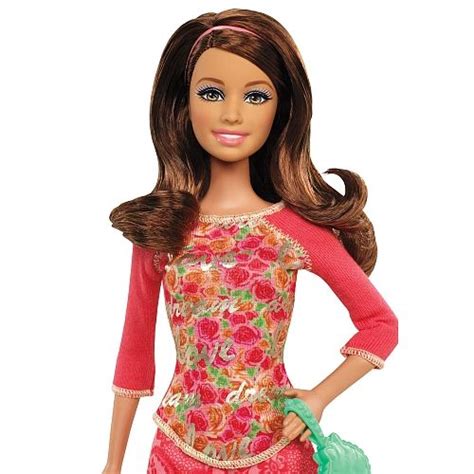 the doll is wearing a pink dress and carrying a green handbag in her right hand