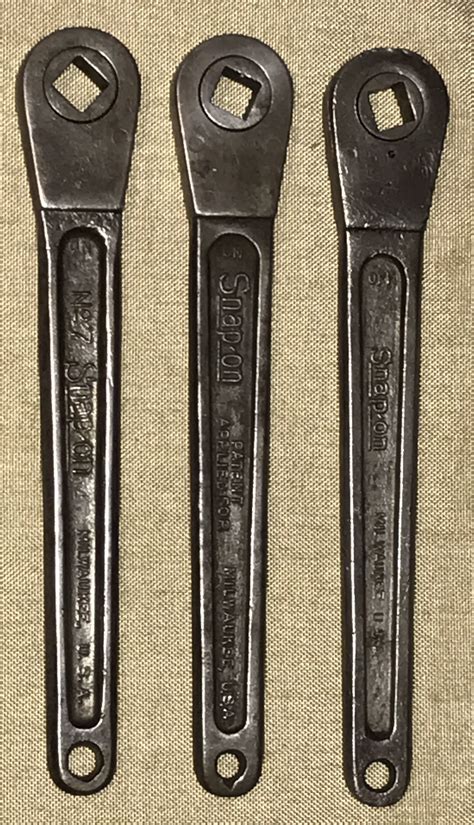 Three Wrenches Sitting Next To Each Other On Top Of A Piece Of Cloth