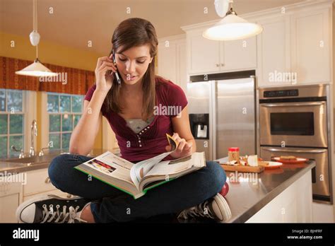 Girl Sitting On Kitchen Counter Stock Photo Alamy