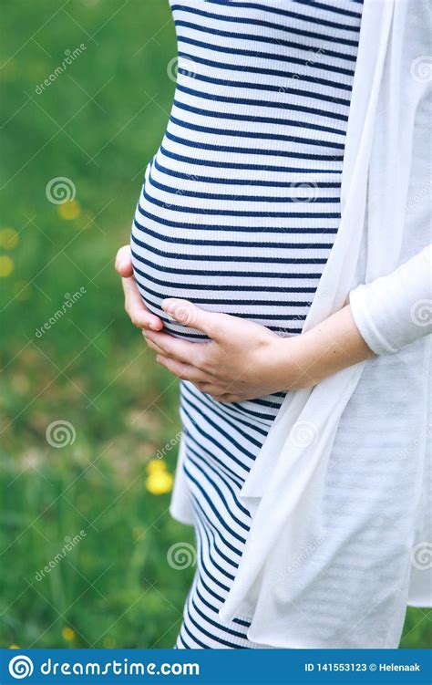Pregnant Young Woman Touching Her Big Belly And Walking In The Park