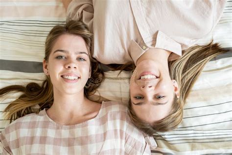 Two Cheerful Blond Teenage Girls Relaxing On Bed At Leisure Stock Image Image Of Beauty