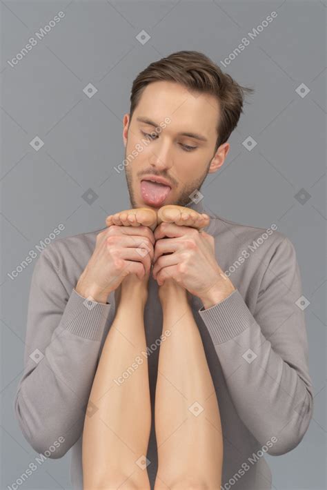 若い男が女性の足を舐めようとしています のフォト