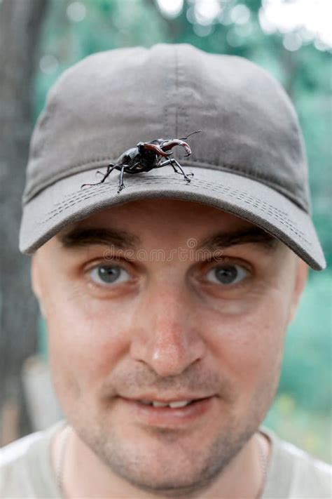 A Large Insect Red Book Stag Beetle Crawls Over A Man Stock Photo