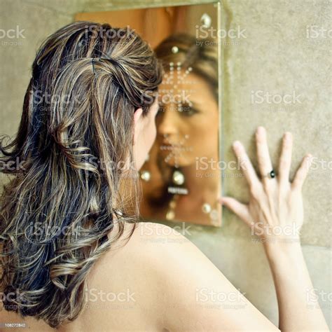 Young Woman Staring At Herself In Mirror Stock Photo Download Image