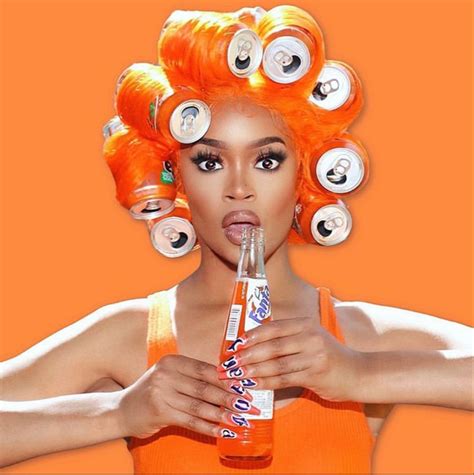 a woman with orange hair is holding a soda bottle in front of her face and has cans on her head