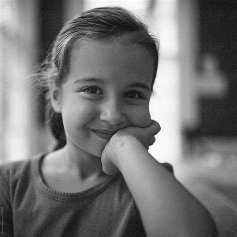 Portrait Of A Smiling Young Girl Resting Her Face In Her Hand By Stocksy Contributor Jakob