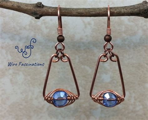 Copper Wire Earrings With Blue Glass Beads Hanging From Them