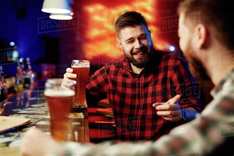 Man Drinking Beer And Laughing With His Friend Stock Photo Dissolve
