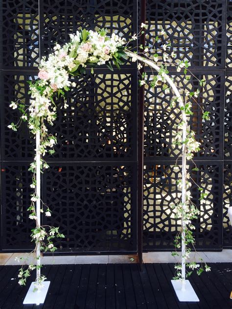 An Outdoor Wedding Ceremony With White Flowers And Greenery In Front Of