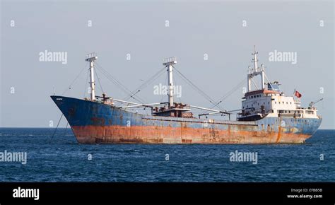 A Rusty Cargo Ship Is Anchored In Sea Stock Photo Royalty Free Image