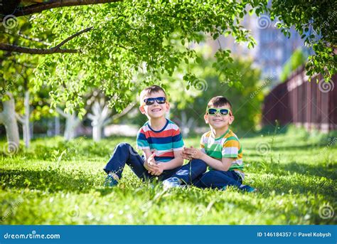 Happy Summer Holidays Two Happy Children On A Green Lawn At A Summer