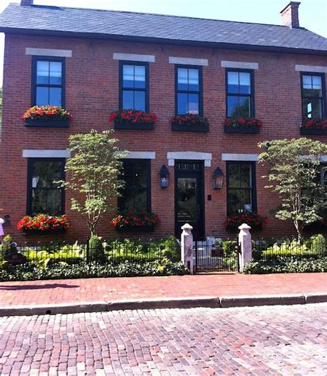 A house with black brick is even more appealing because the bricks add a lot of texture to the house. Black trim on red brick, black window boxes - via ...