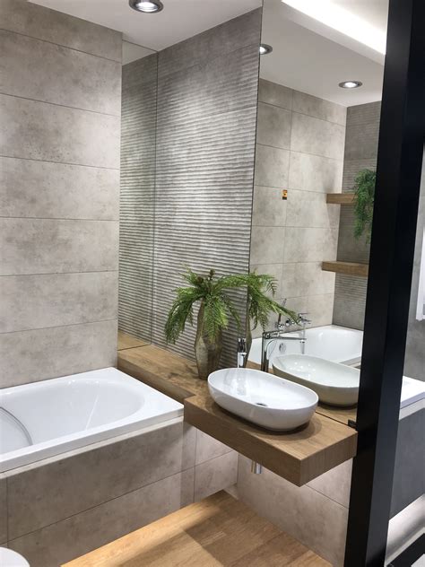 A Bathroom With Two Sinks And A Bathtub Next To A Plant In The Corner