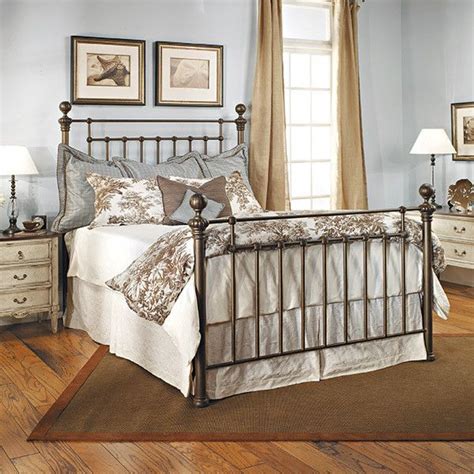 A wrought iron canopy bed accented with a blush pink linen headboard is complemented with burlap tassel pillows and flanked by painted nightstands lit by white lamps. Old Biscayne Ayr Antique Wrought Iron Bed in 2020 | Wrought iron beds, Painted bedroom furniture ...