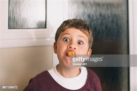 Portrait Of Boy With Food In Mouth Pulling Faces High Res Stock Photo