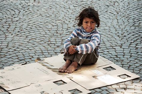 Unknown Homeless Kid Sitting On The Street Stock Editorial Photo
