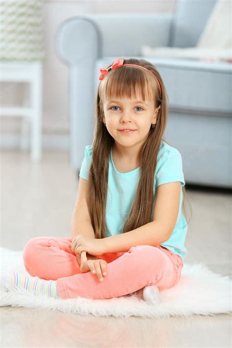 Premium Photo Little Cute Girl Sitting On Carpet On Home Interior