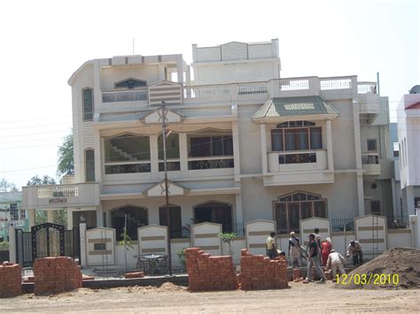 Modern house construction step by step process. White paint on Existing two storey house with mumty ...