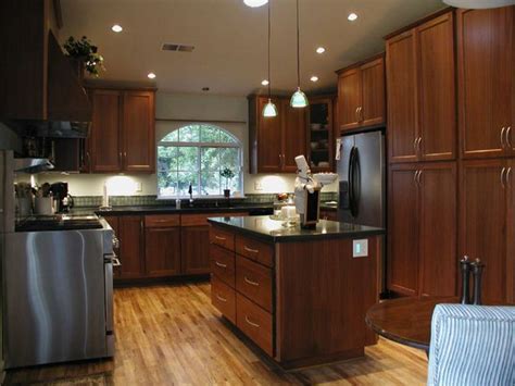 Our showroom features countertops, hardware, cabinets and flooring. Dark oak cabinets, light floor, black countertop ...