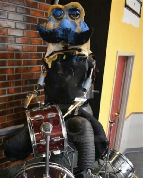 A Statue Of A Drummer Is Sitting On Top Of A Drum Kit