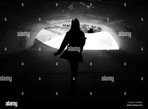 Woman Walks Alone Under A Tunnel Stock Photo Alamy
