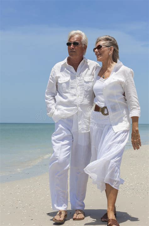Happy Senior Couple Walking By Sea On Tropical Beach Stock Image