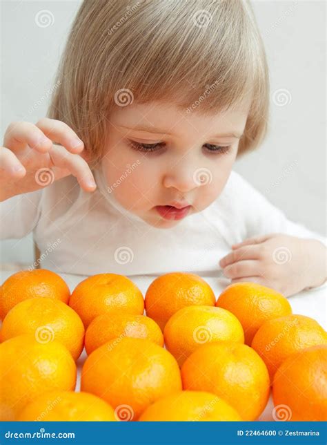 The Baby Girl Is Selecting A Tangerine Stock Photo Image Of Fruit