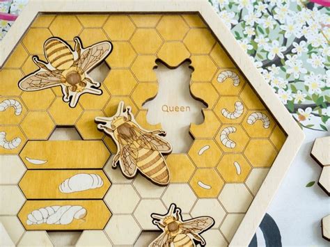 Three Wooden Bees Sitting On Top Of A Honeycomb