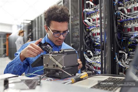 Male It Technician Fixing Equipment In Server Room — Headshot Sitting