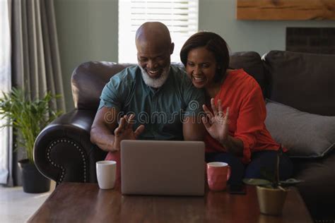 Senior Couple Making Video Call On Laptop In Living Room Stock Image