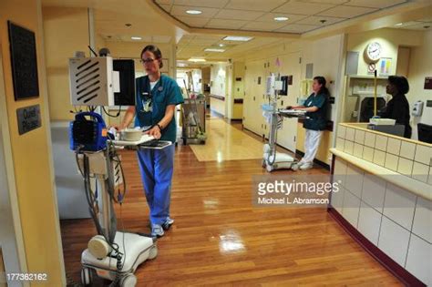 Photo Of Nurses Entering Patient Data On Portable Electronic Modules