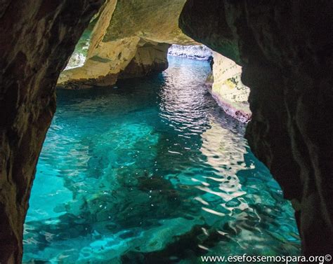 The Inside Of A Cave With Clear Blue Water
