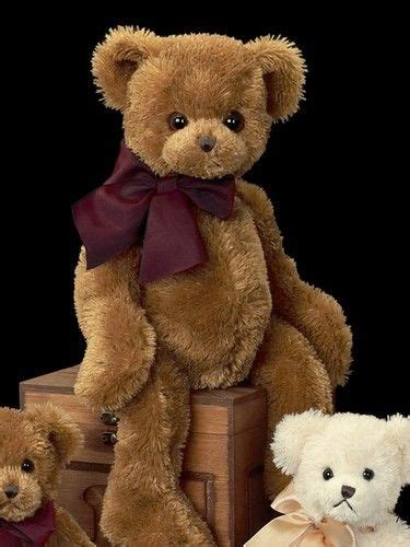Three Teddy Bears Sitting Next To Each Other On Top Of A Wooden Box