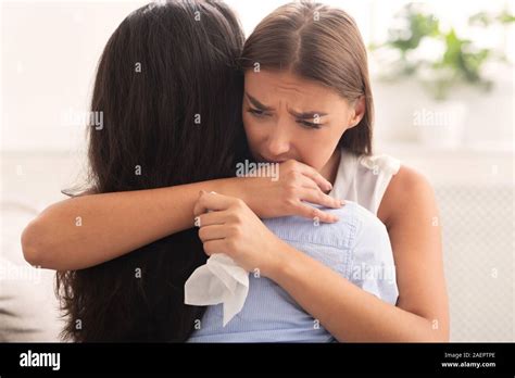 Supportive Woman Hugging Depressed Friend Comforting Her At Home Stock