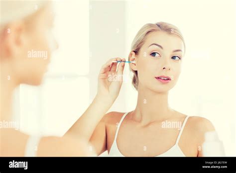Woman Cleaning Ear With Cotton Swab At Bathroom Stock Photo Alamy