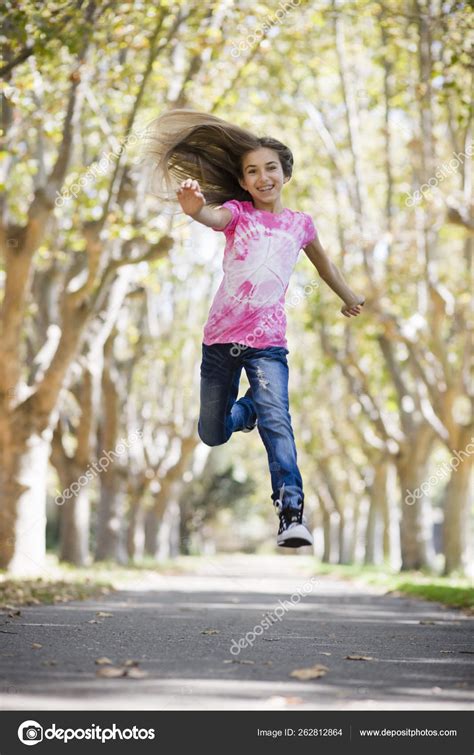 Portrait Smiling Tween Girl Jumping Pathway Trees Stock Photo By
