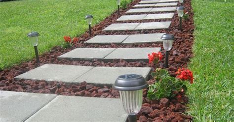 To keep grass from growing between paver stones, be sure to install them on a thick base of tamped down sand and fine pebbles. Front Walkway built out of inexpensive cement pavers, red lava rocks, and solar lights | Hometalk