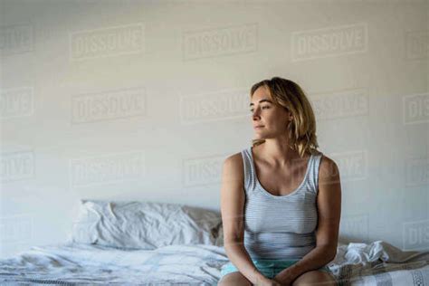 Woman Sitting On Bed Stock Photo Dissolve