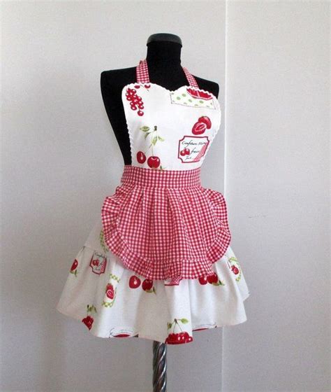 an apron dress is displayed on a mannequin headdress with cherries