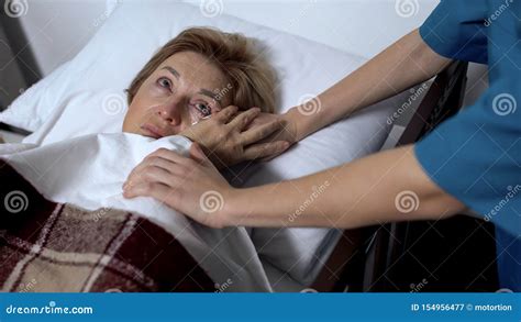 Nurse Wiping Tears Of Ill Patient Lying In Sickbed Support And Empathy Concept Stock Image
